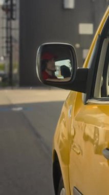 Paketleri teslim ederken erkek kuryenin sarı minibüsü sürüşünün dikey görüntüsü