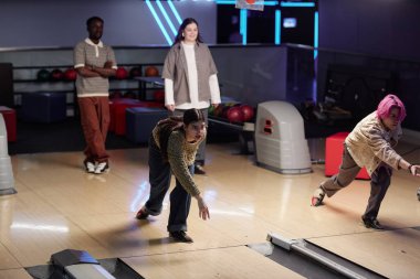 Bir grup arkadaş, kapalı bir bowling salonunda eğlenceli bir bowling aktivitesine girişiyor. Diğerleri arka plandan izlerken iki kişi bovling oynuyor.