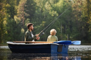 Two people sitting in boat surrounded by lush forest and calm water holding fishing rods on relaxing day fishing on peaceful lake creating bonding moment clipart