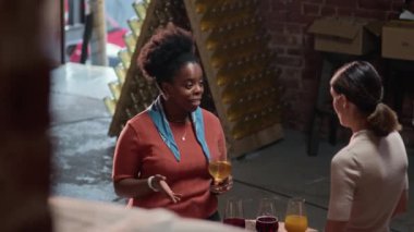 Barda elma suyu dezenfekte edilirken konuşan iki çok ırklı kadının orta boy fotoğrafından.