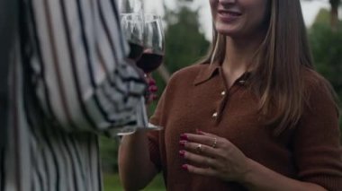 Romantik, genç ve çeşitli çiftin kadeh tokuşturup, yaz akşamları gün batımıyla arka bahçede buluşurken çekilmiş yavaş çekimleri.