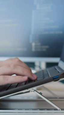 Ofisteki dizüstü bilgisayarda tanınmayan erkek programcıların el bilgisayarı daktilo kodları.