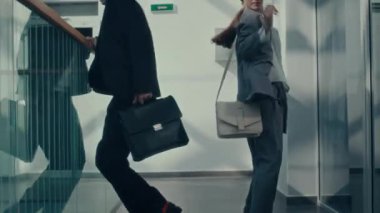Modern iş merkezinin koridorunda takım elbiseli iki tuhaf ofis çalışanının modern dans gösterisi.