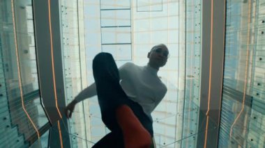 Erkek dansçının modern kapalı alanda cam tavan altında sanatsal solo performans sergilediği son görüntü.