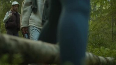 Yaz serüvenleri sırasında yemyeşil ormanda yürürken bir grup yürüyüşçünün yere basması.