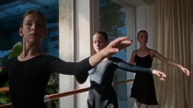 Sunlit Dans Stüdyosu 'nda kalçaları ile dans eden üç genç artistik dansçının orta boy fotoğrafı.