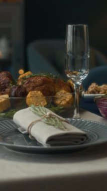 Dikey olarak hiç kimse Noel şenlikli yemek masasında leziz bir rosto, aperatifler, salatalar ve taze meyvelerle çevrili ve zarif sofra takımı ve şampanya bardaklarıyla tamamlanmış.