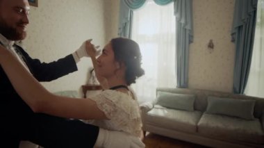 Viktorya dönemi resmi kıyafetli çiftin klasik tasarlanmış geniş salonlarda dans ederken birbirlerinin gözlerinin içine baktıkları orta yavaş bir çekim.