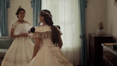 19. yüzyılın zarif aristokrat, dantelli genç kadını klasik ortamda elinde yelpazeyle dururken küçük kız kardeşi ona gizli bir aşk mektubu uzatıp kaçıyordu.