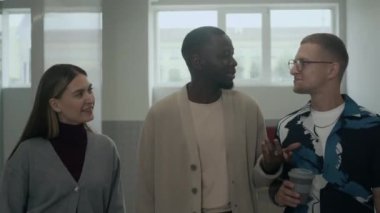 Modern ofis koridorunda yürüyen, sohbet eden üç farklı meslektaşın belden yukarısını çekiyoruz.