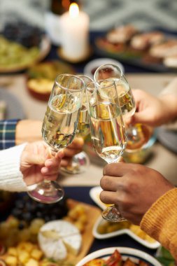 Noel 'i kutlamak için kadeh tokuşturan insanların dikey çekimleri. Ev partisinde, fotokopi uzayı.