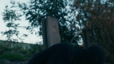 Beyaz erkek suçlu, suçunu itiraf ettikten sonra kayalıklarda oturup derin derin nefes alırken yüzünden siyah kar maskesi çıkarıyor.