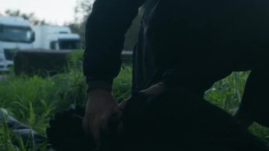 Profesyonel polis, yakalandıktan sonra yeşil çimlerin üzerinde yatan suçluya kelepçe takıyor.