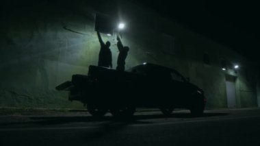 Tanınmayacak haldeki iki suçlunun kamyon yatağında dans ederken ve başarılı bir soygundan sonra birbirlerini kucaklarken havaya para atması.