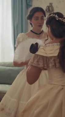 Viktorya dönemi zarif elbiseli genç bir kadının dikey görüntüsü. Sevdiğinden mektup alıyor. Diğer emlak sakinlerinden gizlice bir bayan arkadaşının ona ilettiği mektup.