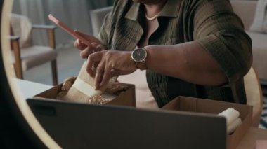 Yaşlı Afrikalı Amerikalı kadının elinde akıllı telefon ile blogu için boks videosu açarken çekilmiş el kamerası görüntüleri.