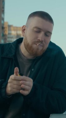 Kafkas sakallı polis ya da dedektifin dikey beli sigara içerken ve arka planda gündüz manzarası olan rıhtım kenarındaki parmaklıklara yaslanırken ipuçlarını düşünürken.