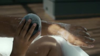 Tanımlanamayan bir kadının kolunda banyo süngeri kullanırken rahatlatıcı, iç atmosferde köpük banyosu yapması.