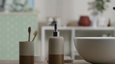 Tanımlanamayan siyah bir adamın banyo tezgahındaki bambu diş fırçasını alıp sabah rutinine başlarken çekilmiş fotoğrafı.