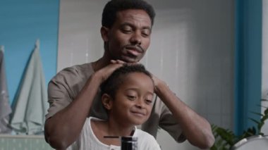 Orta boy Afro-Amerikan baba ve benzeri oğlunun banyo aynasında yansımalarına bakarken sabahları birlikte tımar ritüellerini paylaşırken.
