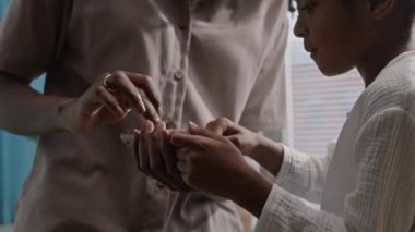 Beyaz pijama giymiş Afro-Amerikalı çocuk sabahın erken saatlerinde banyoda tezgahta otururken annesinin telefonuyla oynuyordu.