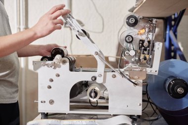 Erkek fabrika işçisinin şişelere etiket yapıştırma makinesiyle etiketleme uyguladığı el yapımı elma şarabı fabrikasındaki etiketler, kopyalama alanı.