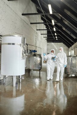 Orta ölçekli, başörtüsü takmış Müslüman bir kadının konuşma kulübü grubunda yeni kelime dağarcığıyla konuşurken geniş bir masada dizüstü bilgisayar kullanırken görüntüsü.