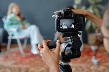 Stüdyoda kamerayı tripoda kuran ve dijital ekranda ekipman ayarlarıyla çalışan genç çocuğu kapat, boşluğu kopyala