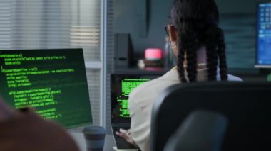 Genç kadın melez programcının beyaz erkek arkadaşına yazarken ve modern ofiste akşamları beşlik çakarken görüntüsü.