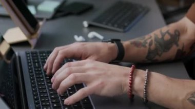 Erkek programcıların elleri dizüstü bilgisayarda yazarken ve kadın meslektaşı akşam ofisinde bilgisayar programında çalışırken görüntüyü kaldır.