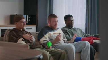 Üç farklı spor aşığı TV 'de rahat bir dairede maç izlerken tutku ve heyecan gösteriyorlar. En sevdikleri takımı destekliyorlar.