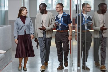 Düşük açılı çekimde, gözlüklü yakışıklı erkek yazılım mühendisi dizüstü bilgisayarla kod yazarken iş yerinin önünde otururken uygulamaları geliştiriyor.