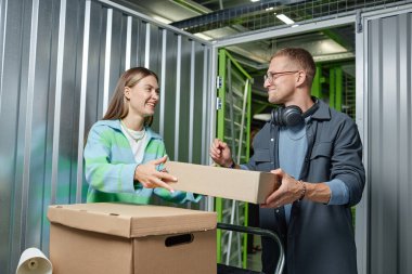 Taşınırken ya da daireyi birlikte boşaltırken depoda duran karton kutudan sevgiliye gülümseyen bir adamın orta boy fotoğrafı.