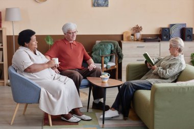 Oturma odasında oturup kitap tartışarak eğlenen son sınıf öğrencilerinin olduğu uzun bir sahne.