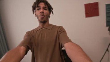 Sevgilisinin elini tutan neşeli, çift ırklı adamın görüntüsü. Dairede birlikte dönüp eğlenirken.