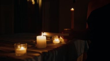 Tanımlanamayan genç bir kadının mum sehpasına yaklaşıp dua eden bir mum yakarak loş ışıklı katolik kilisesinin ruhsal atmosferinde sunduğu görüntüler.
