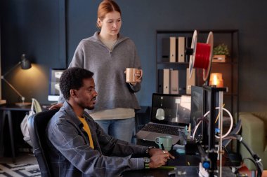 Modern ofis ortamında ileri teknoloji projesinde çalışan insanlar detayları tartışıyor ve fikirleri paylaşıyor, yenilikçi çözümlere ve ilerlemeye odaklanıyor