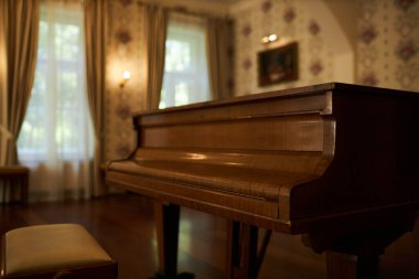 Klasik antika kapakla kaplı zarif ahşap piyanoyu kapat. Yumuşak, sıcak ışıklandırmayla aydınlat, kopyala alanı.