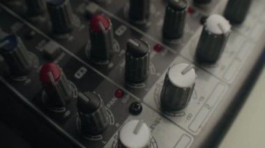 Gelişmiş kayıt stüdyosundaki gri karıştırma konsolunun yakın plan görüntüsü.