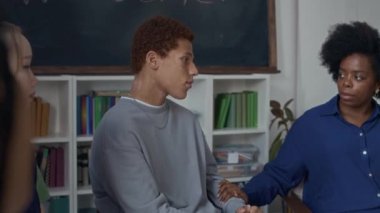 Genç Afrikalı Amerikalı kadın psikolog. Çok ırklı gençlerle grup terapisi yapıyor. Tavsiye ve destek veriyorlar.