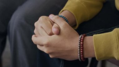 Elleri burkulmuş, gergin ve tedirgin bir adamın kesikli çekimi.