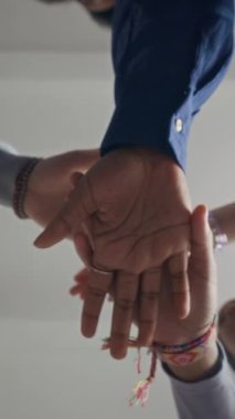 Dikey çekim altında gençlerin el ele tutuşup olumlu takım motivasyonu, birlik hissi, destek ve işbirliği yaratması