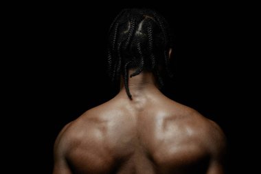 Akortlu siyahi adam arka planda sade bir ışıkta dikilirken stüdyoda siyah arkaplana karşı poz verirken, boşluğu kopyala