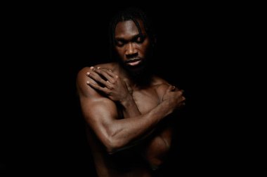 Siyah adamın orta boy portresi. Gözleri kapalı. Çıplak omuzlarıyla barışçıl bir şekilde kendini kabullenme hissi veriyor.