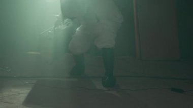 Olay yerine, sarı barikat bandıyla izole edilmiş ve siyah plastik torbayla kanıt toplamak için cesede yaklaşan adli tıp uzmanının görüntülerini takip ediyoruz.