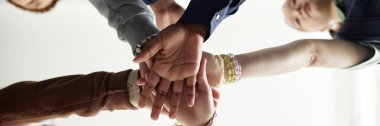Elleri üst üste istifleyen bir grup çocuğun alttaki görüntüsünden başlık biçimi