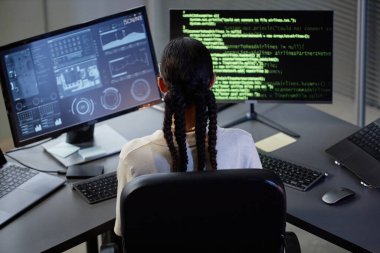 BT şirketinde çalışırken masasında saç stili kodlama yapan kadın programcının arka görüntüsü.