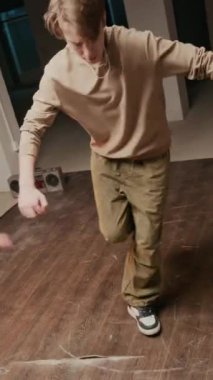 Dikey çekimde, beyaz ırktan, kentsel giyimli Z-B-Boy arkadaşının önünde rock 'ı sahneleyecek ve müzik eşliğinde dans edecek.