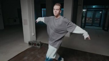 Sokak stili giysiler içinde, el kamerasıyla, doğaçlama yapan ve hip hop yapmaktan zevk alan, serbest dans hareketleri yapan, sokak tarzı giyinmiş, esinlenilmiş beyaz erkek görüntüsü.