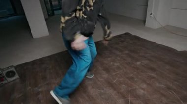 Sokak kıyafetleri içinde sokak dansı yapan, kapalı mekanda dans eden ve yaratıcı en iyi rock hareketlerini sergileyen yetenekli beyaz çocuk.